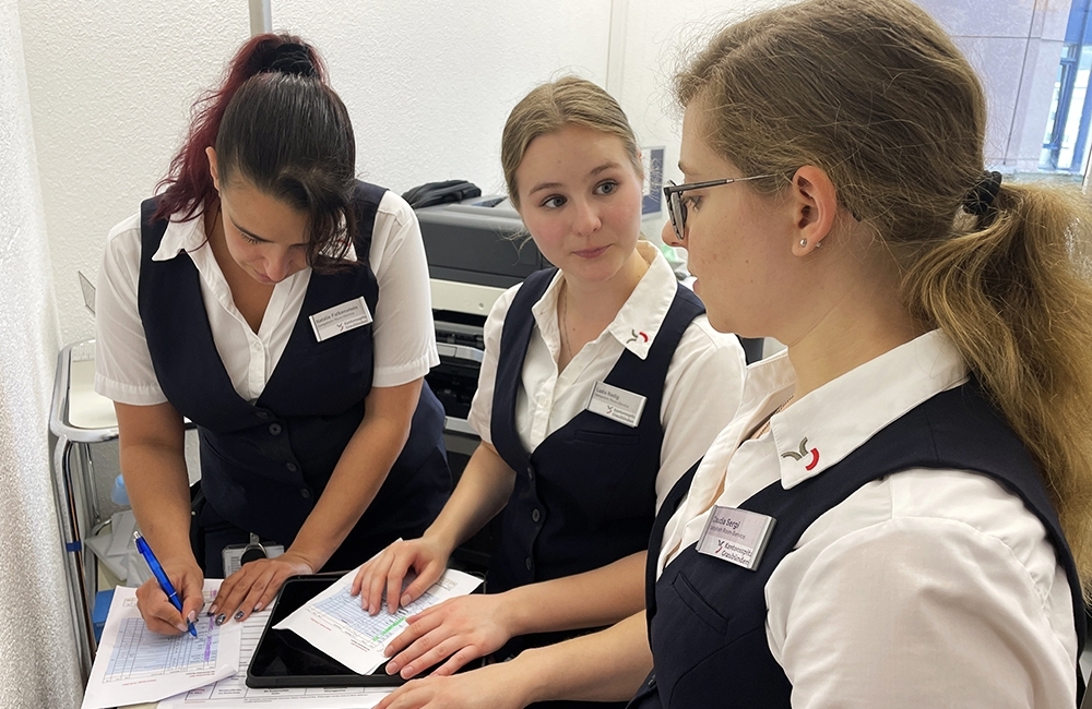 Drei Damen des Room-Service besprechen sich im Büro.